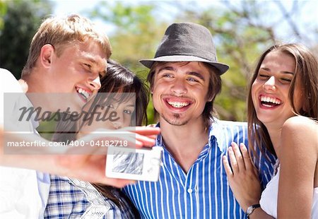 group of happy smiling couples taking picture together in the park