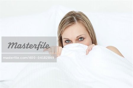 Beautiful woman hiding in her bed at home