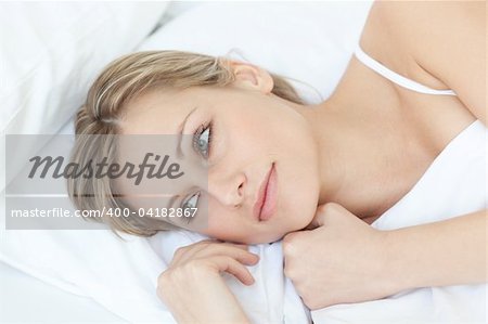 Beautiful relaxed woman lying on her bed at home