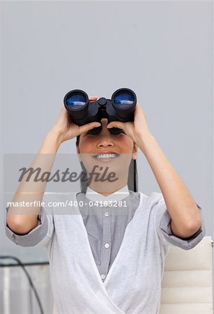 Happy young Businesswoman predicting future success with binoculars