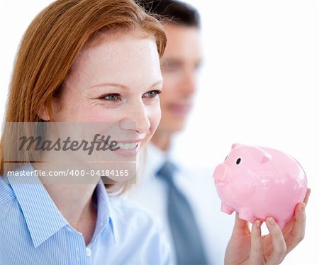 Smiling businesswoman holding a piggybank in the office