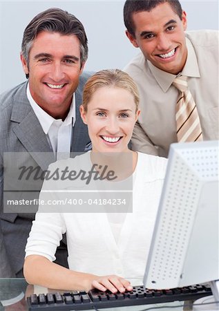 Positive business team working at a computer in the office