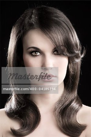 desaturated fashion portrait of beautiful sensual woman with elegant hairstyle over black background
