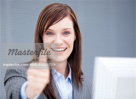 Successful businesswoman with a thumb up in the office