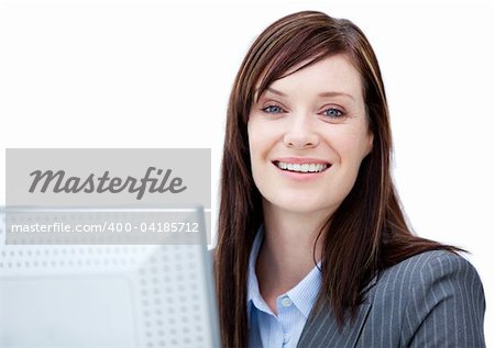 Charismatic businesswoman working at a computer against a white background