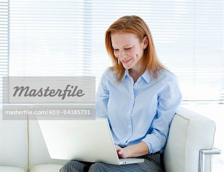 Cute business woman working on a laptop computer in the office