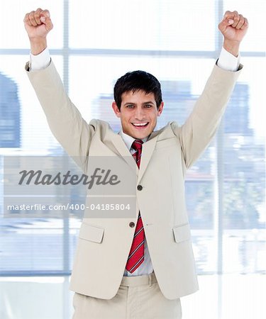 Cheerful businessman punching the air in celebration in the office