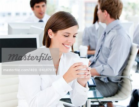 Smiling businesswoman holding a cup of coffee in the office