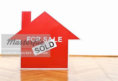 New home concept with house sold sign on the floor of an empty room