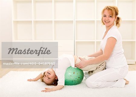 Happy woman and little girl doing gym exercises indoors