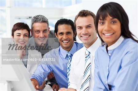 Multi-ethnic smiling business team sitting in a row in the office