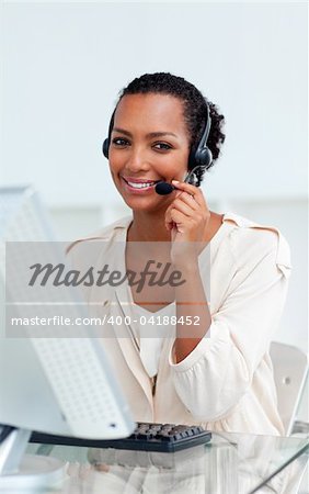 Charming businesswoman with headset on working at a computer