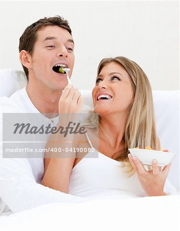 Smiling couple having breakfast against a white background