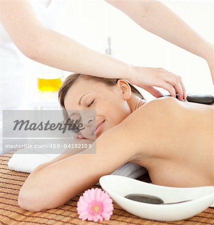 Portrait of a relaxed woman having a massage with stones at the spa