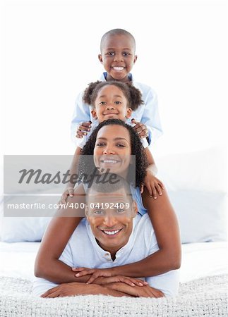Animated family having fun lying down on bed at home