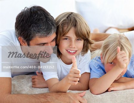 Affectionate father with his children having fun lying on a bed