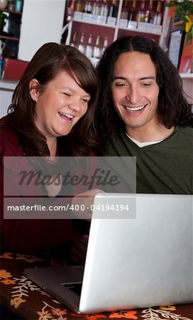 Interracial couple on a laptop at a coffee house