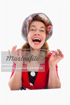 happy middle-aged woman in red with hair rollers - isolated on white