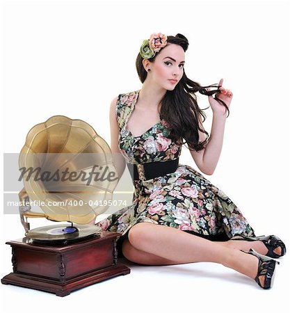 pretty girl listening music on old gramophone isolated on white in studio