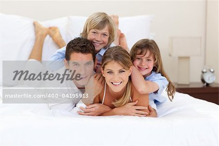 Cheerful family having fun together lying on a bed