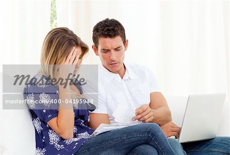 Distressed couple at home angry with so many bills to pay