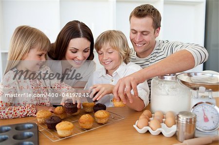 Loving family eating their muffins in the kitchen
