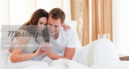 Affectionate couple finding out results of a pregnancy test in their bedroom
