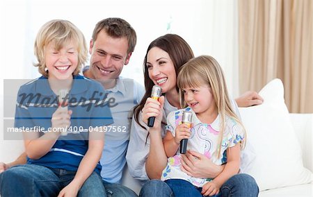 Laughing family singing together on the sofa