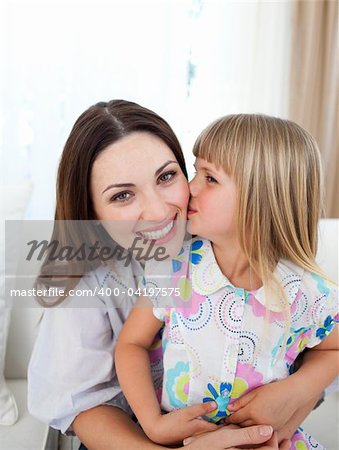 Cute girl kissing her mother in the living-room