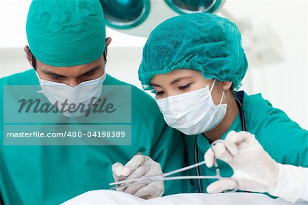 Portrait of two ethnic surgeons in operative room. Medical concept.
