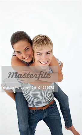 Young boy giving his friend piggyback ride against white background