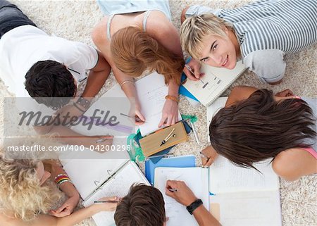 Group of Teenagers lying on the ground studying together