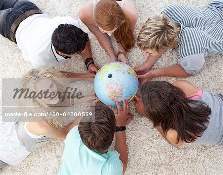 High angle of teenagers lying on the floor examining a terrestrial world