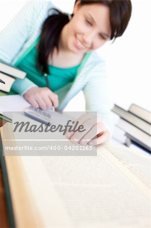 Cheerful student doing her homework on a desk at home