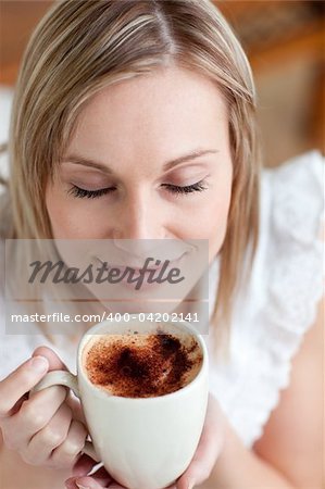 Delighted woman drinking a coffee at home