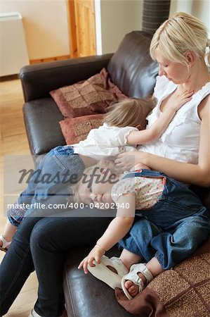 Smiling girl lying  on the sofa with her mother in the living room