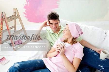 Loving couple having free time together on a sofa with a cup of coffee