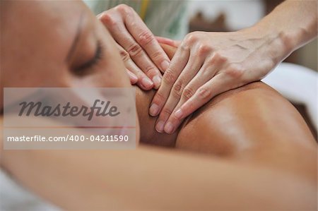 A pretty woman getting a shoulder and back massage at spa and wellness center