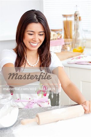 Lively asian woman baking in the kitchen at home