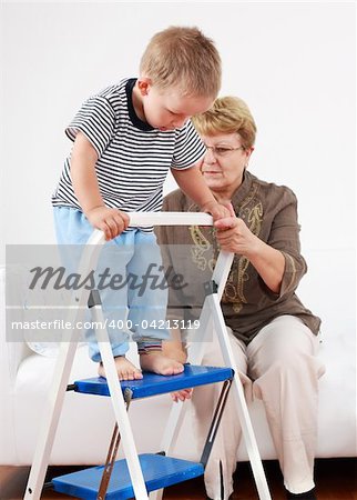 Cute little boy playing with his grandmother and training walking stairs