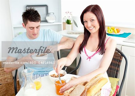 Young caucasian couple having breakfast together in the kitchen at home