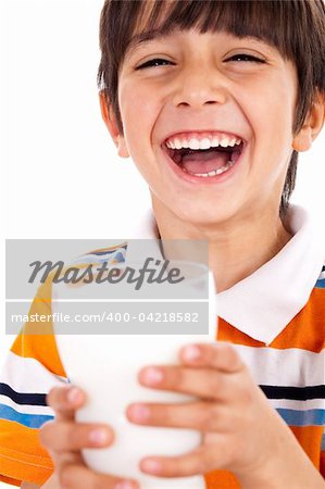 Smiling young boy holding a glass of milk over a isolated white background