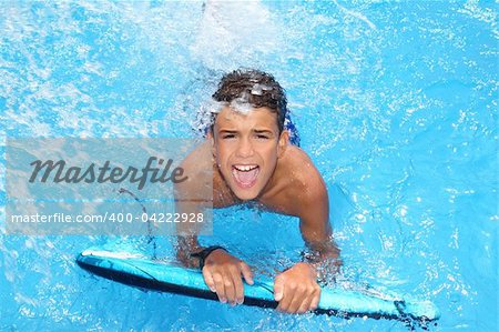 boy teenager surfboard splashing blue water happy in sea pool