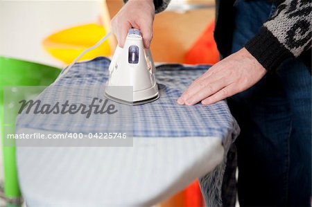 Housework - a man is ironing his shirt