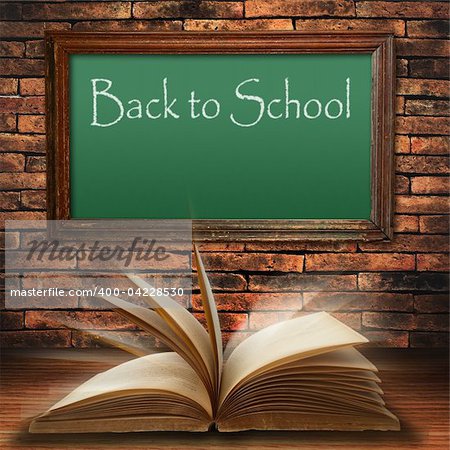back to school blackboard on brick wall with open old book