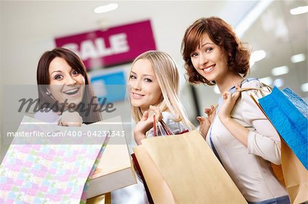 Happy smiling girls in shop with purchases