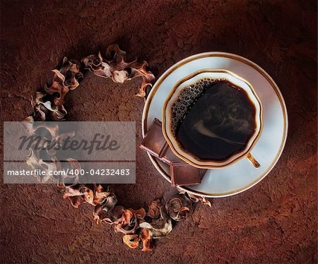 The cup of coffee with chocolate on brown background