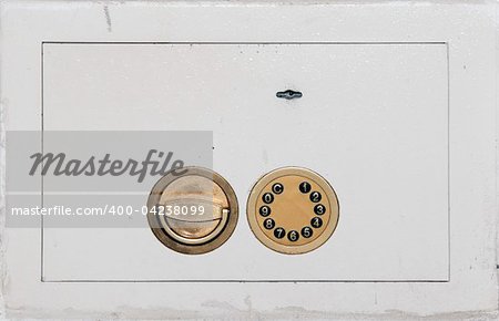white wall mounted safe door with golden locks closeup