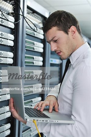 young engeneer business man with thin modern aluminium laptop in network server room