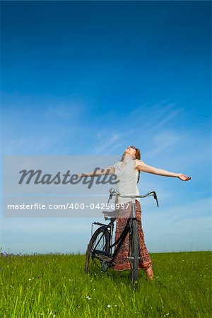 Happy young woman with a vintage bicycle and relaxing